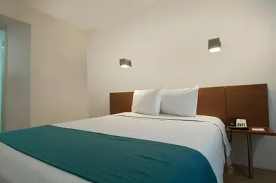 Cama o camas de una habitación en One Puebla FINSA