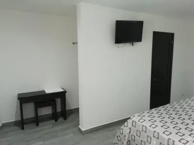 Una televisión o centro de entretenimiento en HOTEL QUINTERO