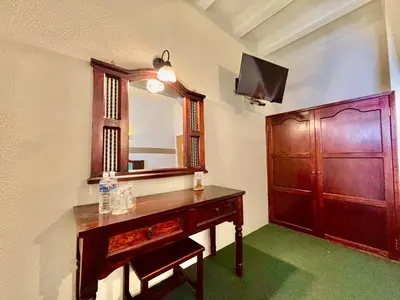 Una televisión o centro de entretenimiento en Hotel Alifer