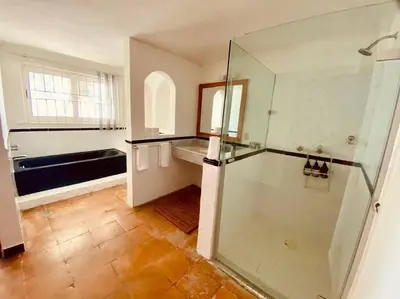 Un baño de Moderna casa de 3 dormitorios con cama King size y vistas al horizonte de la piscina