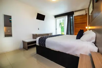 Cama o camas de una habitación en Collection O Hotel Mango,Six Flags Hurricane Harbor Oaxtepec