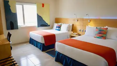 Cama o camas de una habitación en Hit Hoteles Aeropuerto Puebla