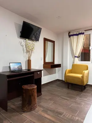 Una televisión o centro de entretenimiento en Hotel & Suites Cerro Roj0