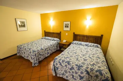 Cama o camas de una habitación en Hotel Real de Naturales