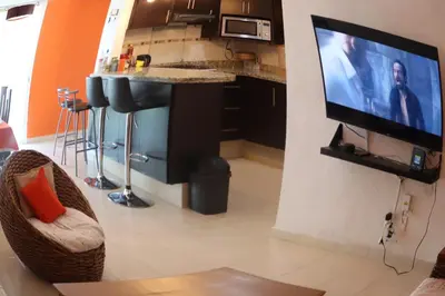 Una televisión o centro de entretenimiento en depto relajante Diamante