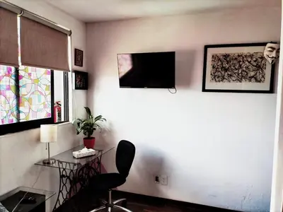 Una televisión o centro de entretenimiento en Departamento COMPARTIDO en el Corazón de la Ciudad