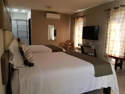 Cama o camas de una habitación en Hotel Garden Suites Tonalá
